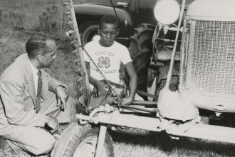 Child in 4-H learning to fix a tractor