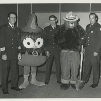 Harrisburg, PA Fire Chief Charles Henry (left) &amp; two firemen with Smokey Bear and Woodsy Owl 