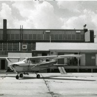 Dispersing plane parked in front of loading platform of box assembly building