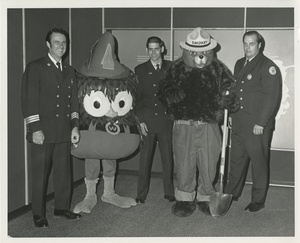Thumbnail for the first (or only) page of Harrisburg, PA Fire Chief Charles Henry (left) &amp; two firemen with Smokey Bear and Woodsy Owl .