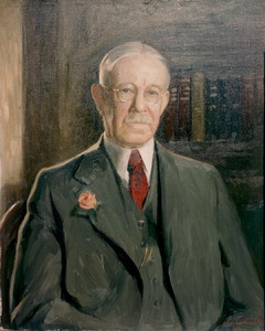 Painted portrait of J. Horace McFarland, wearing wireframe glasses, a red tie, and a dark grey suit with a rose pinned to the lapel. A bookcase sits in the background.
