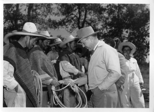 Official handling a rope and interacting with campesinos